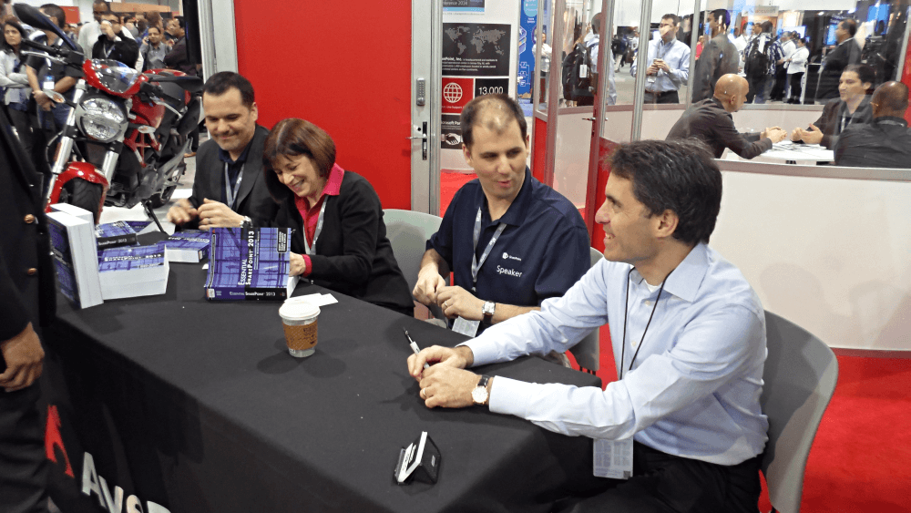 Scott Jamison, Susan Hanley, Chris Bortlik, and Jeff Teper sign books at AvePoint's booth.
