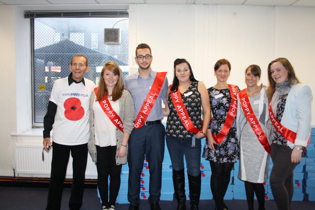 A Poppy Appeal volunteer coordinator poses with the AvePoint team.