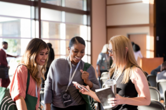 Diverse women attending expo smile at smart phone photos picture id1177065306