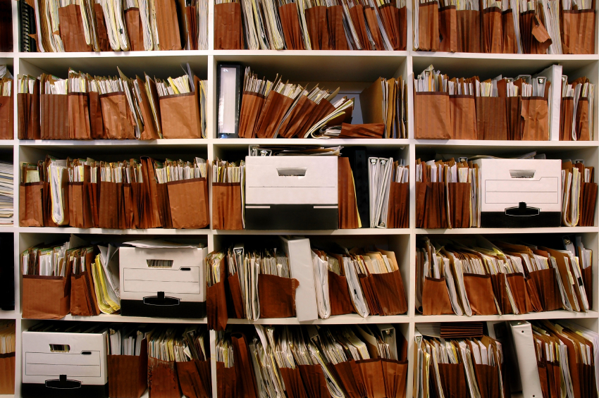 Piles of document on a book shelf