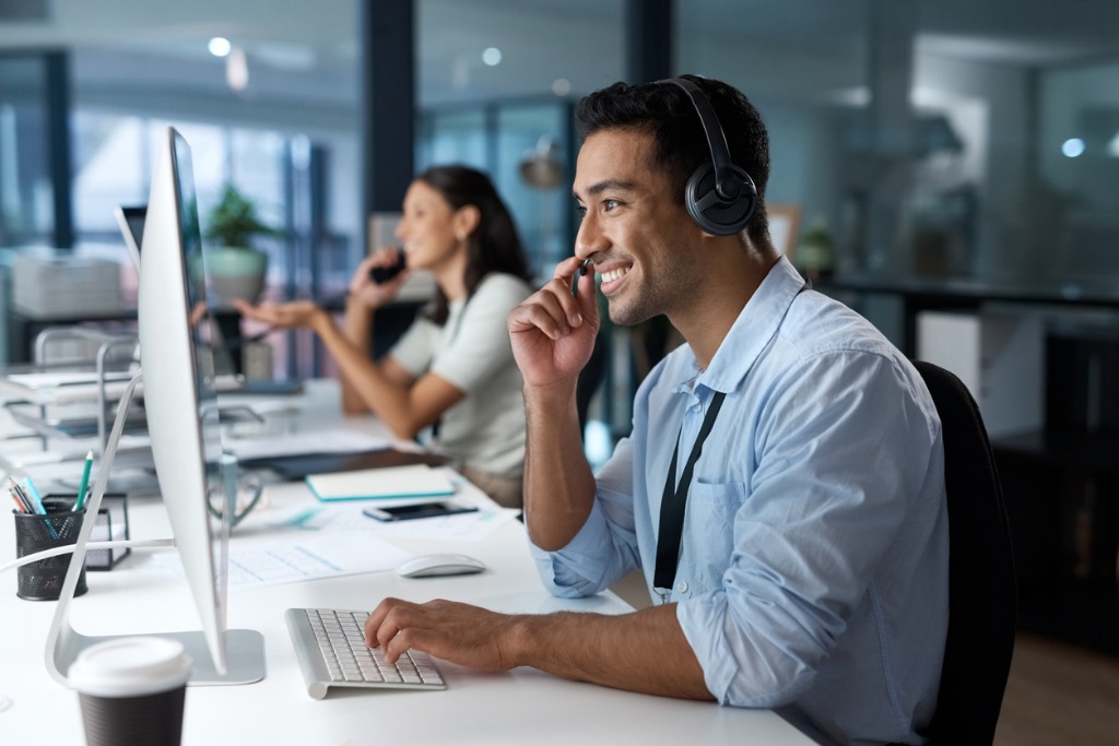 Shot of a young man using a headset and computer in a modern office picture id1329866233