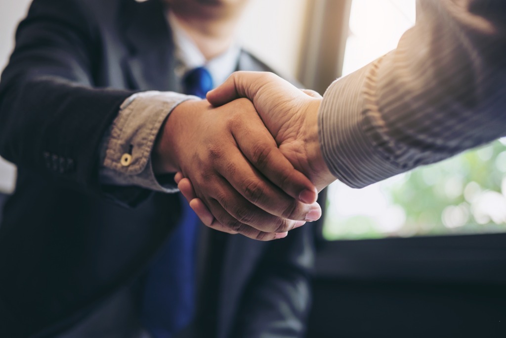 Two business men shaking hands during a meeting to sign agreement and picture id886031704