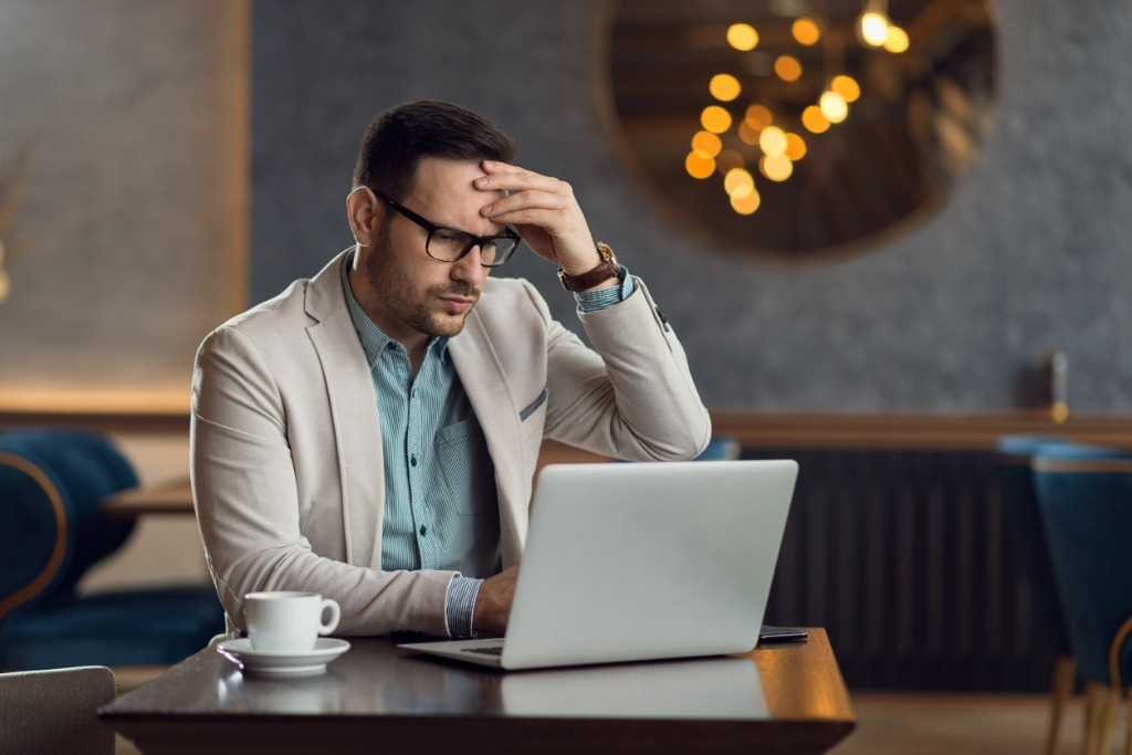 Worried businessman using laptop in a cafe picture id1136176178