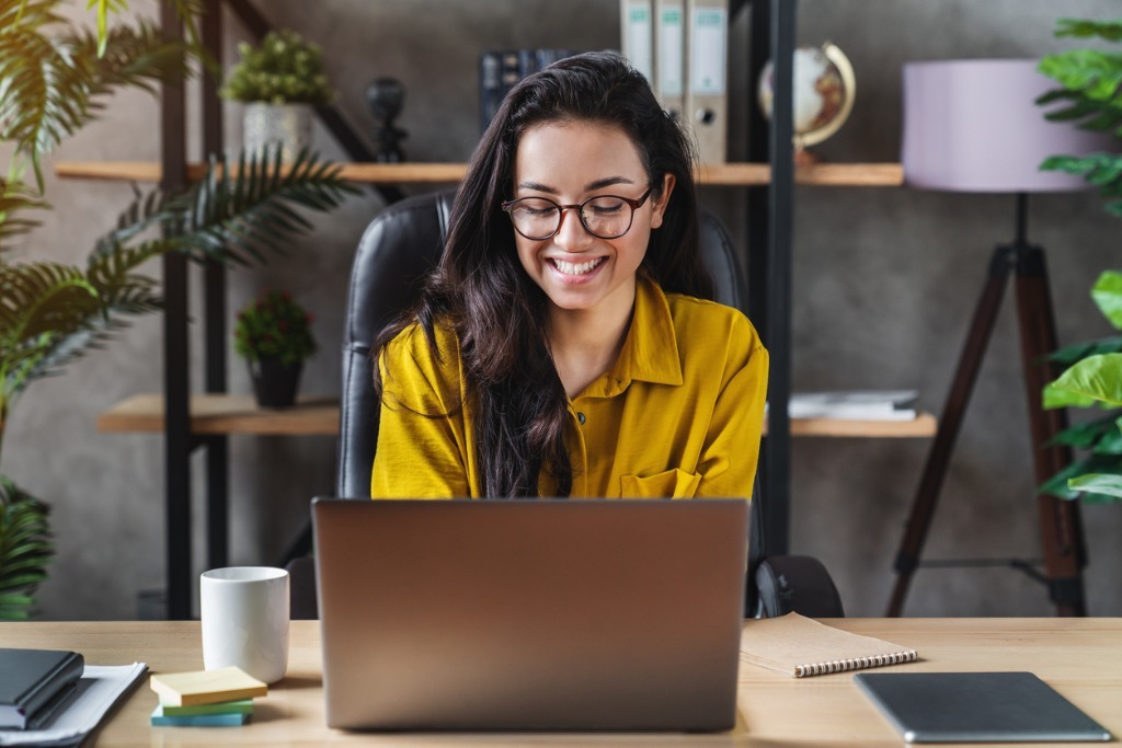 Young happy cute business woman sit indoors in home office using picture id1254993890